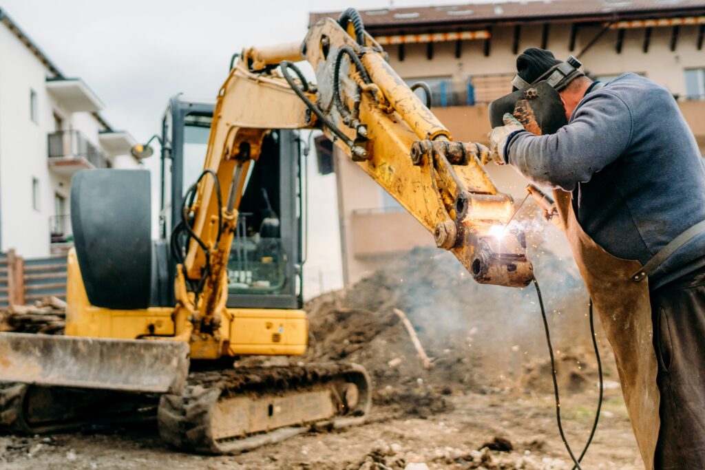 construction and building site, broken excavator and professional welder